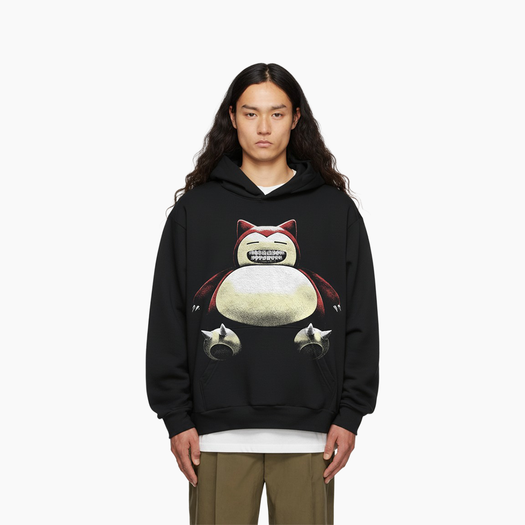 Person wearing a black hoodie with a cartoon character design on a white background